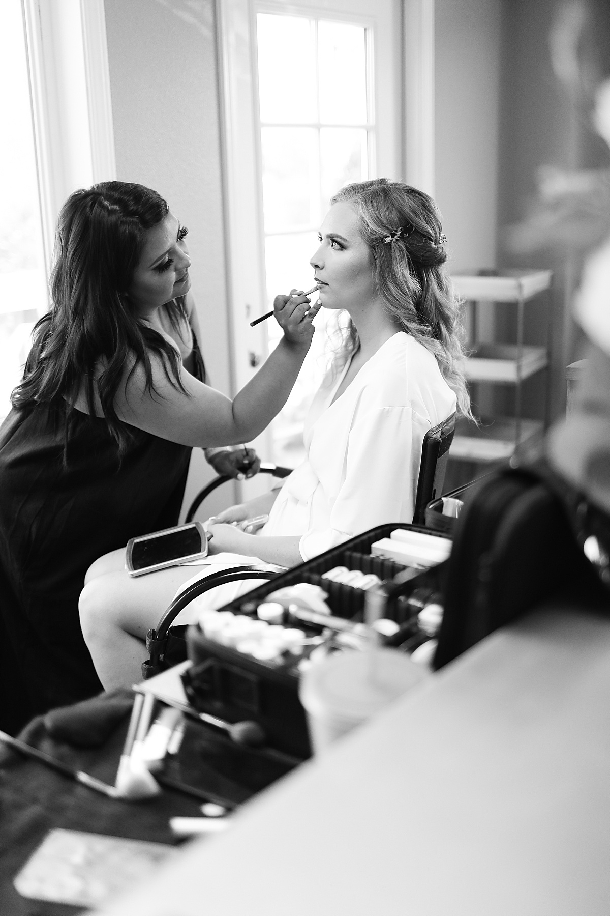 bride in lounge robe gets hair and makeup done for romantic California vineyard wedding