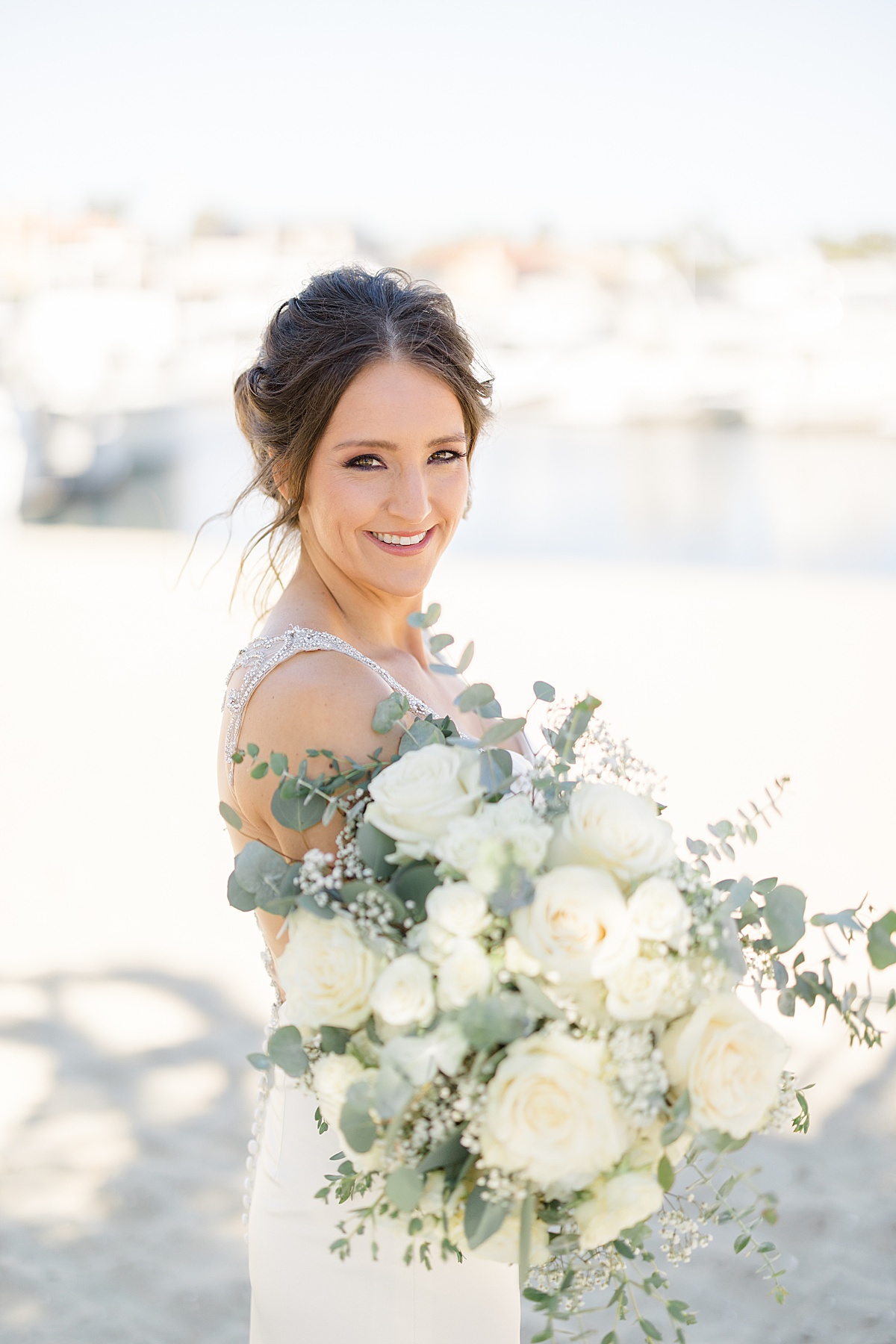 bride with white rose and eucalyptus bouquet poses for Hunter Hennes Photography