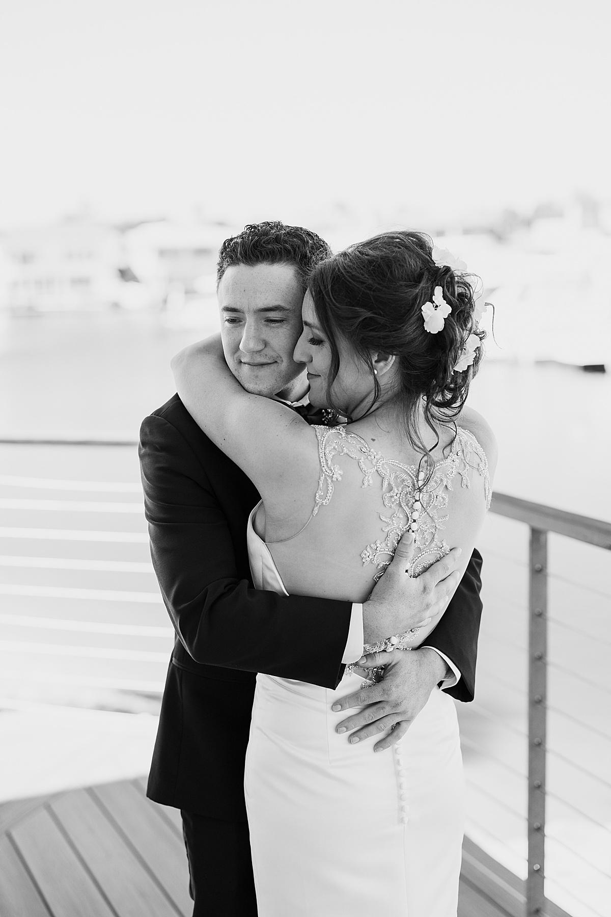 bride in embellished sheer lace backed gown hugs groom during shoot with Hunter Hennes Photography