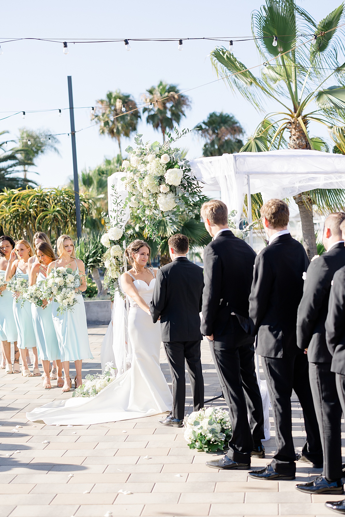 bride and groom at classy beach wedding share vows during ceremony shot by Destination wedding photographer