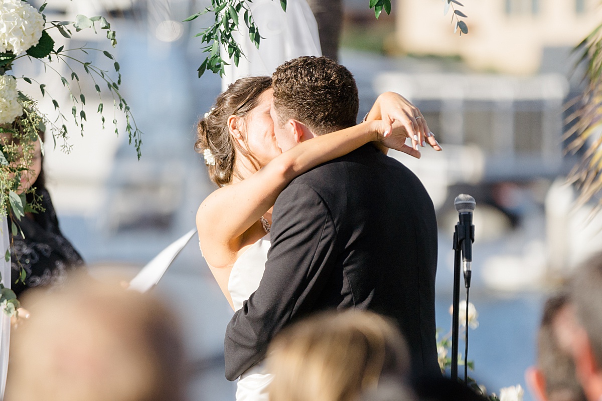 bride and groom kiss during beachside ceremony shot by Destination wedding photographer