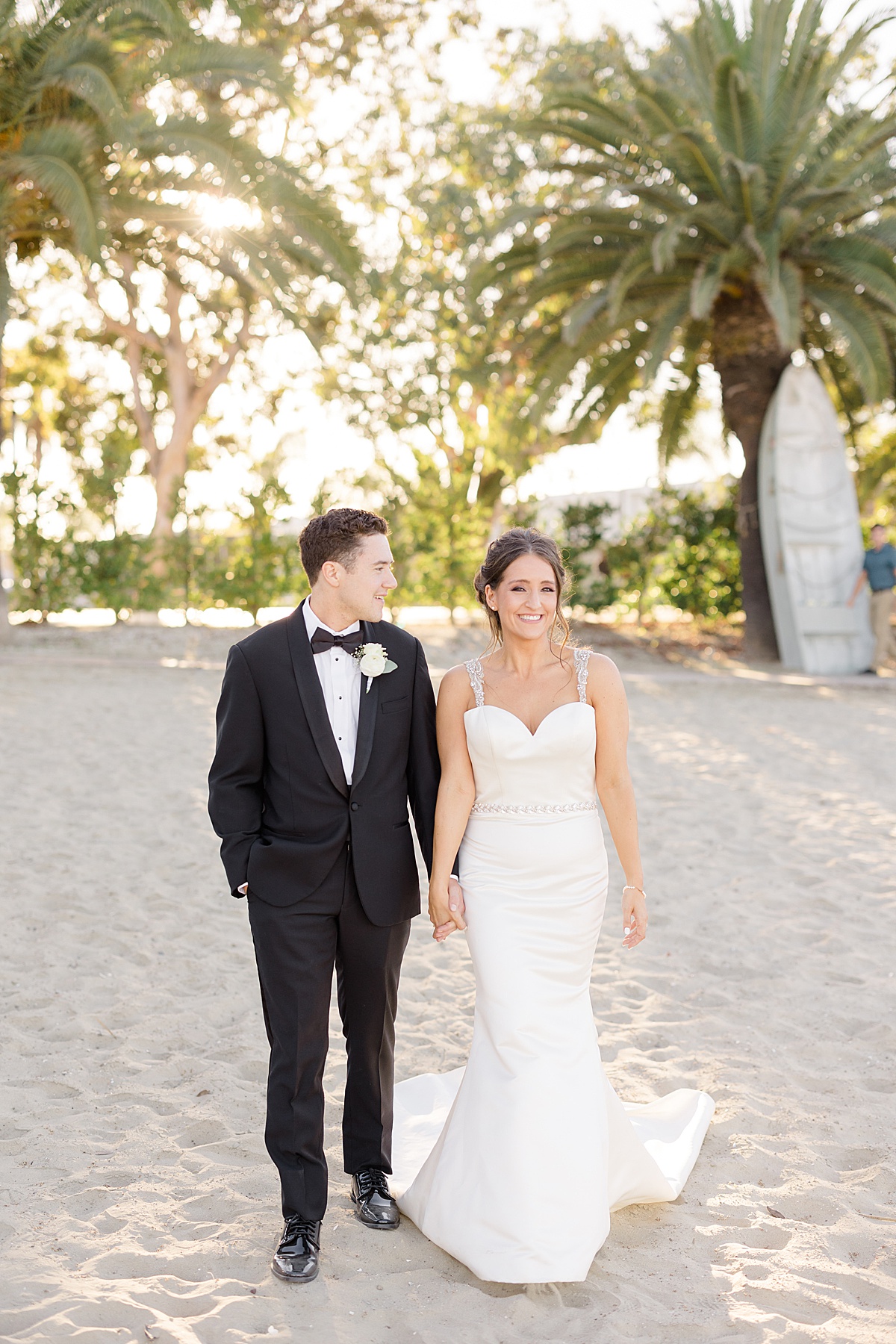 classy bride and groom pose on beach with palm trees after ceremony shot by Destination wedding photographer