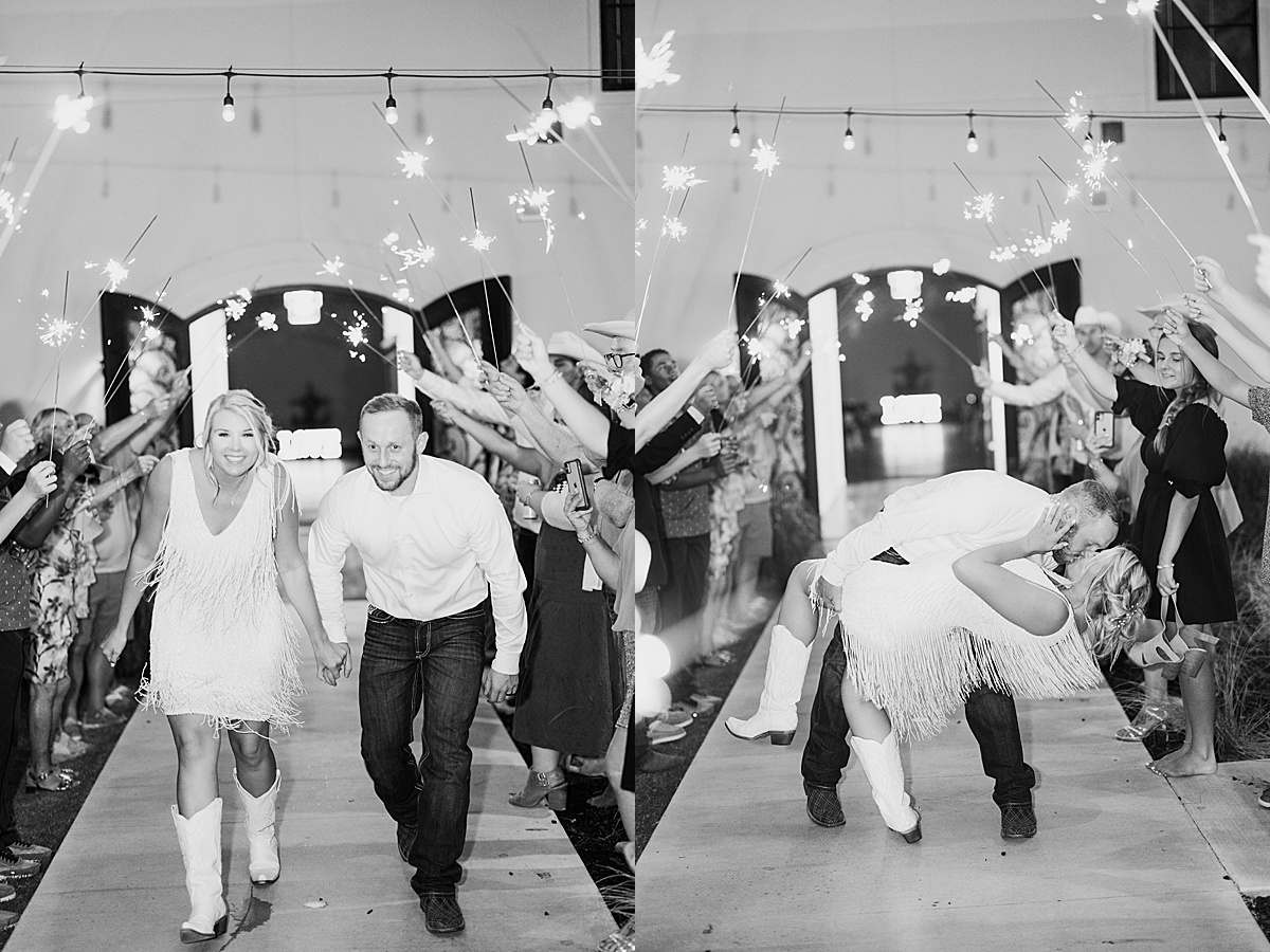 bride in white boots and fringe mini dress and groom in jeans leave wedding reception while guests hold sparklers | Hunter Hennes Photography