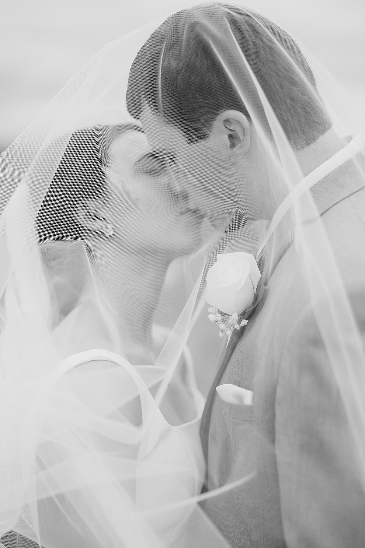 bride and groom kiss under romantic veil during classy ceremony shot by destination wedding photographer