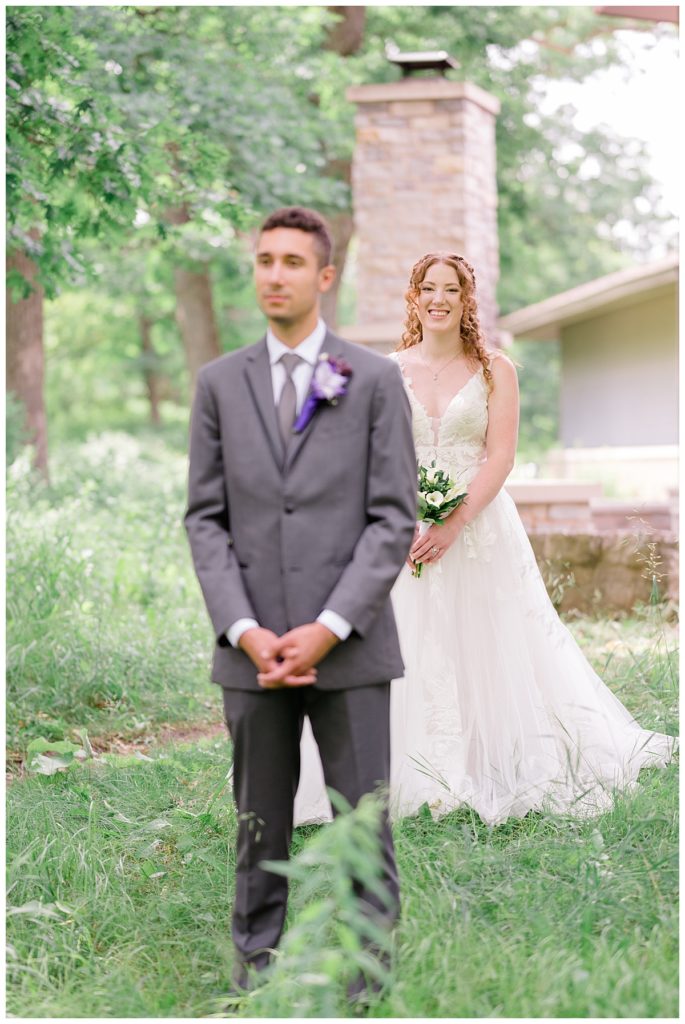 bride stands smiling behind groom by destination wedding photographer