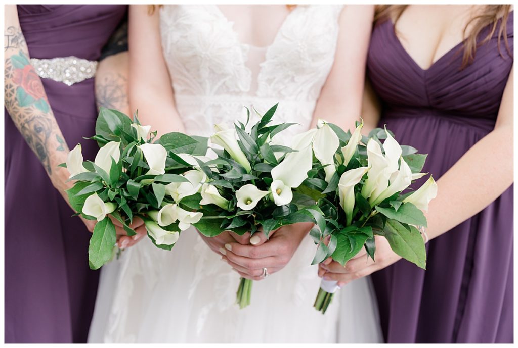 bridesmaids hold bouquets together with bride by destination wedding photographer