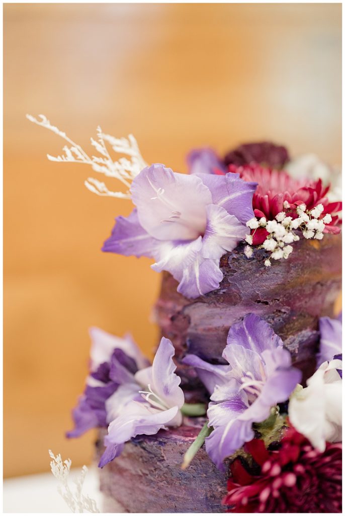 purple and fuchsia flowers and decoration on cake at Minnesota park wedding