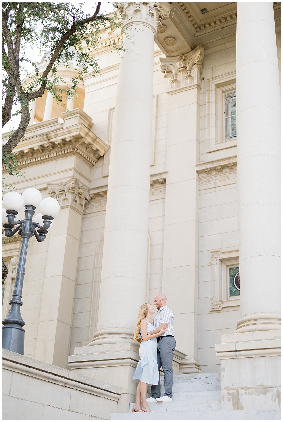 couple stands on steps holding each other by destination wedding photographer
