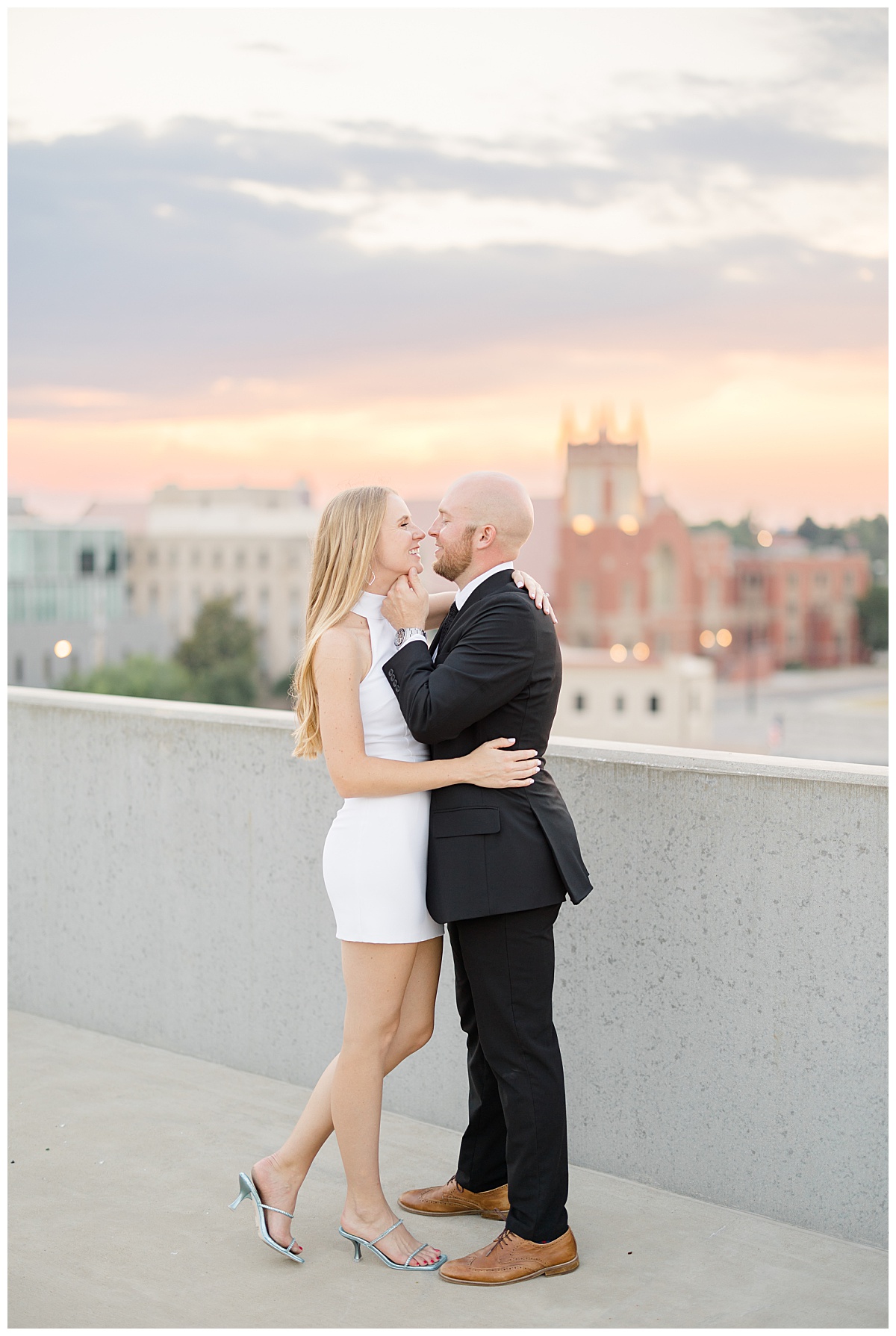 couple holds each other close and man holds woman's face on rooftop by Hunter Hennes Photography