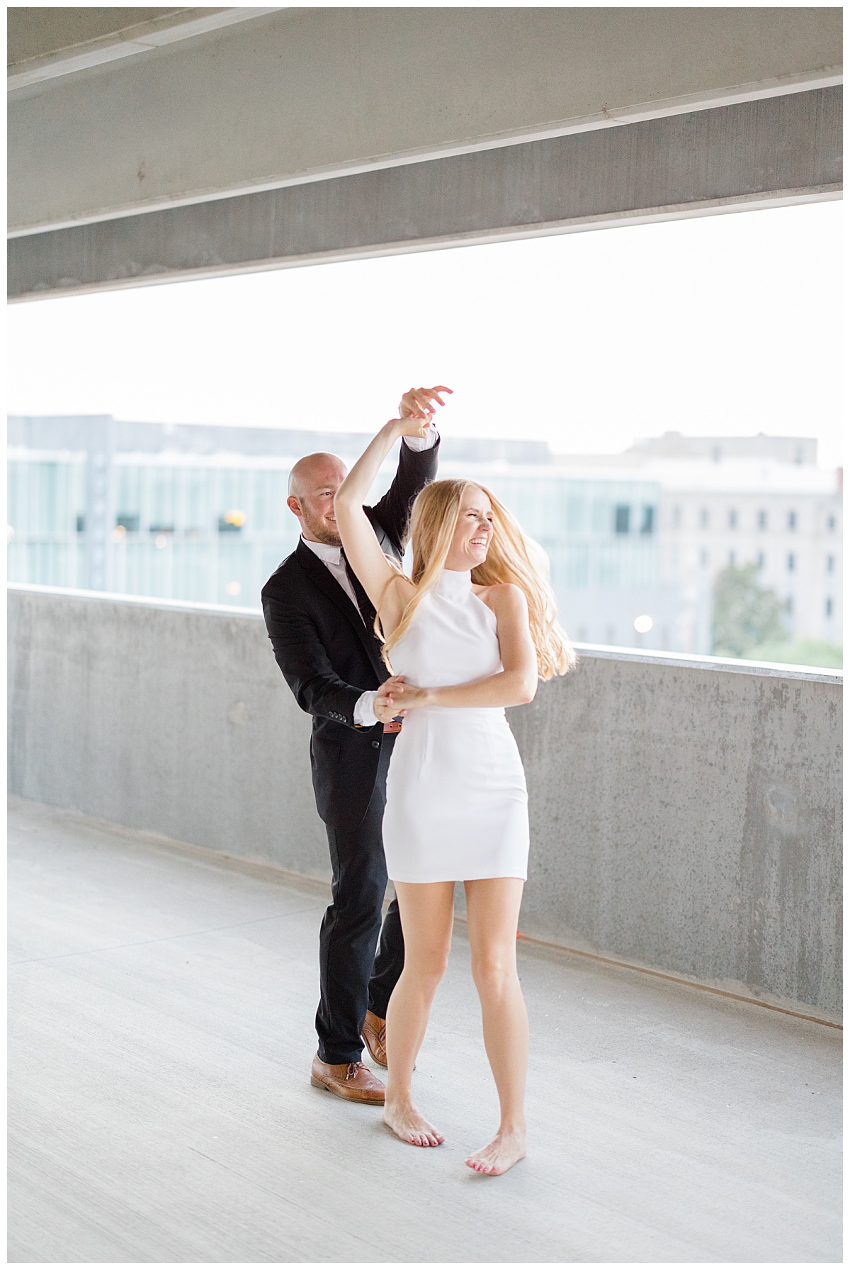 man spins woman while dancing on rooftop by Hunter Hennes Photography