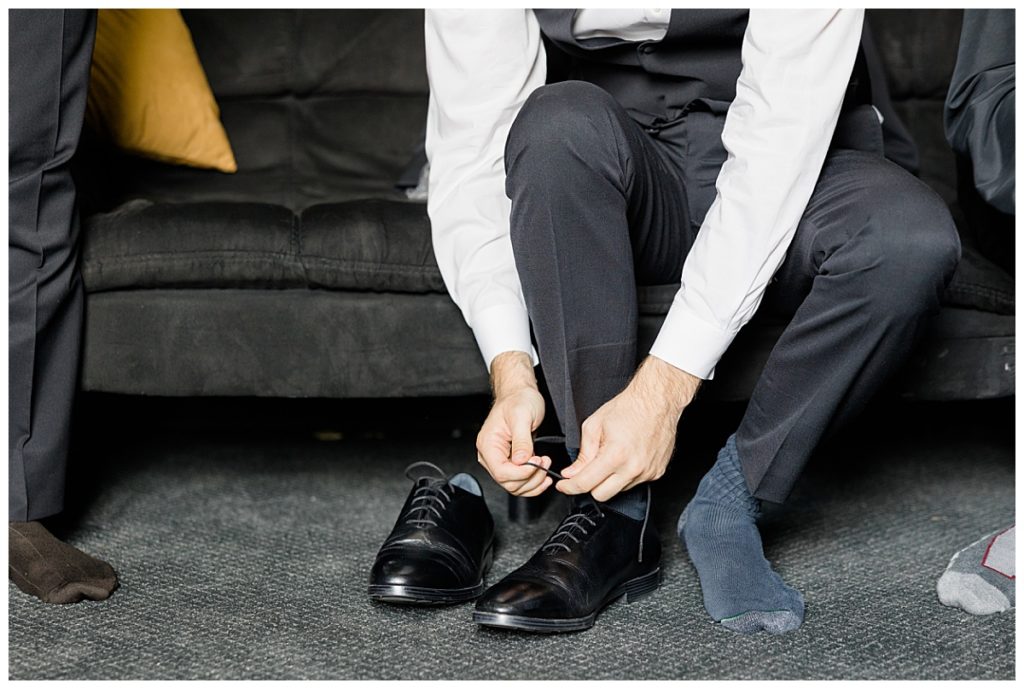 man ties shoes at romantic Oklahoma wedding