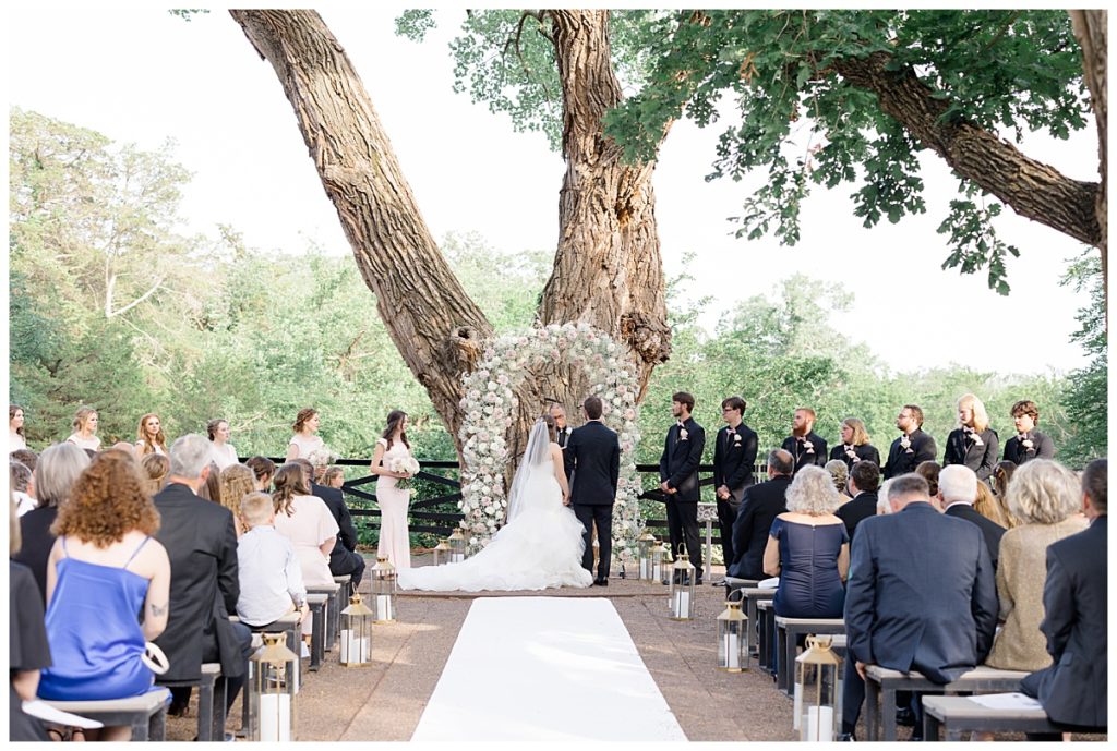 outdoor ceremony under large tree at romantic Oklahoma wedding