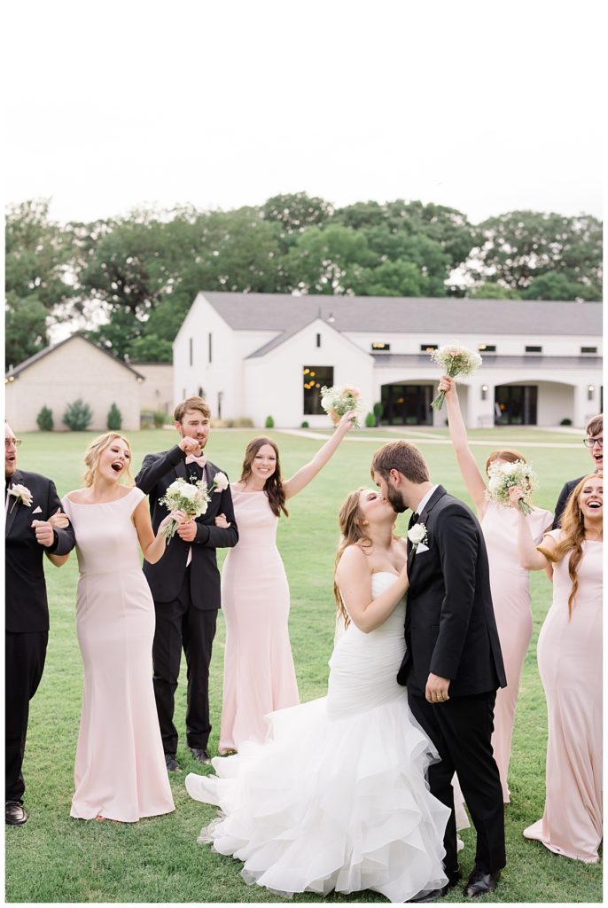 couple kisses while others cheer at romantic Oklahoma wedding