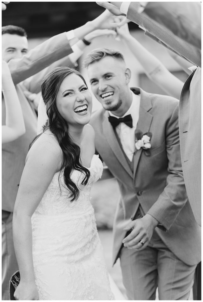couple smiles and laughs together in wedding attire by Hunter Hennes Photography