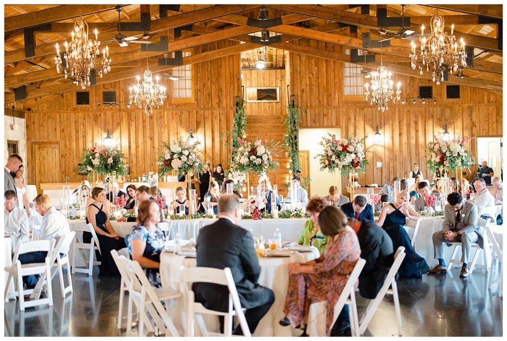 wedding reception decorated with chandeliers, florals, and greenery by Hunter Hennes Photography