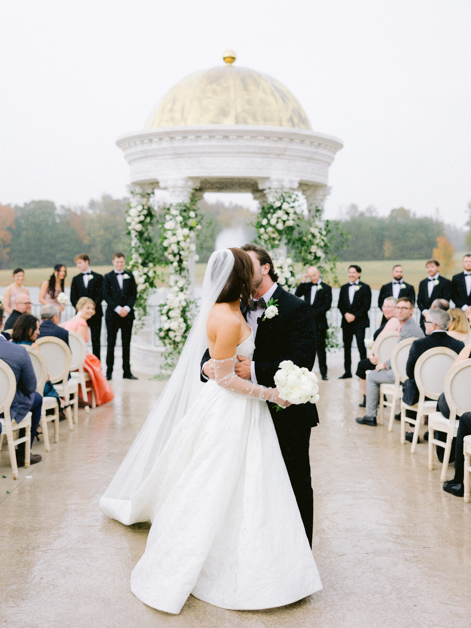 bride and groom kissing in aisle.