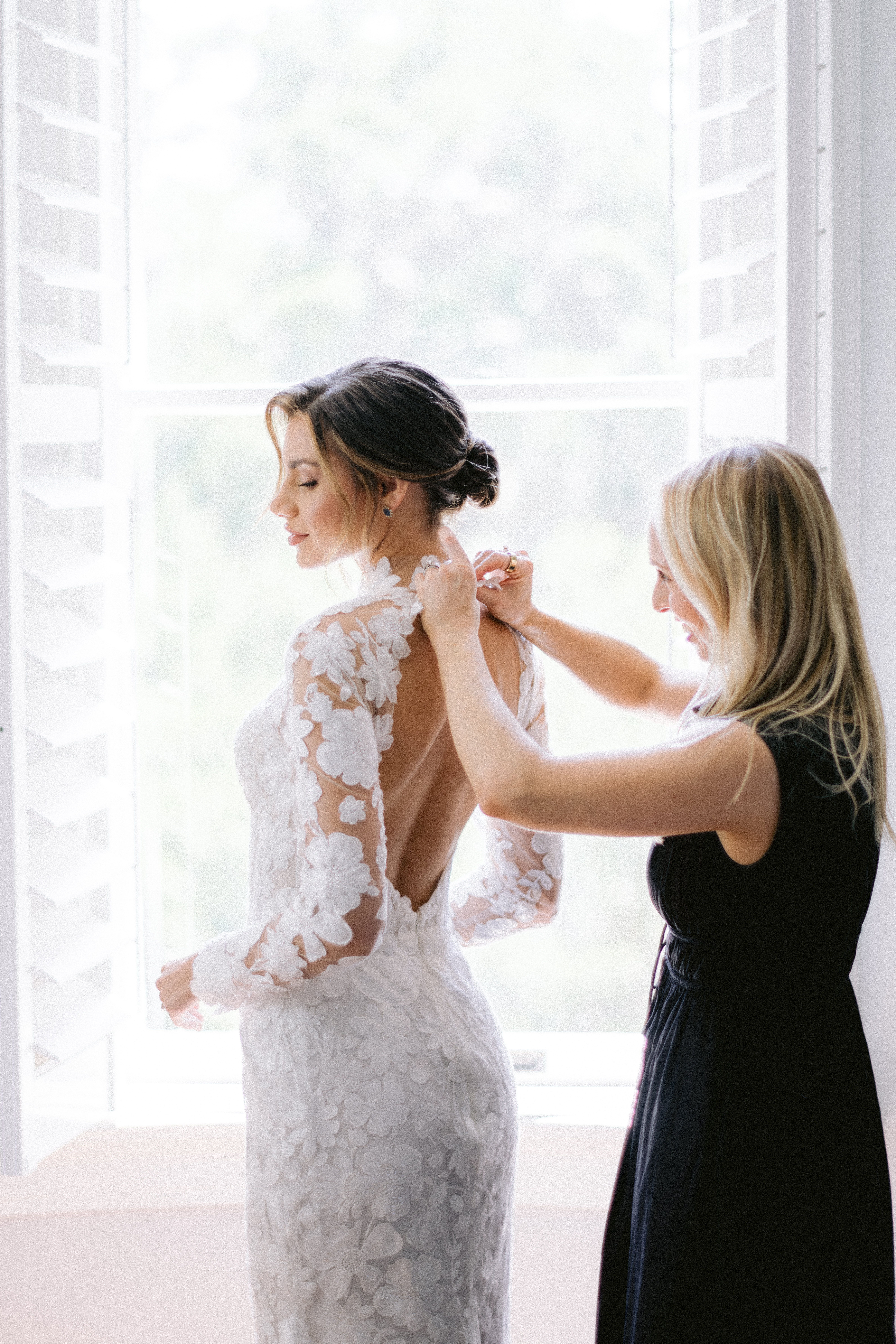 bride being zipped up into dress