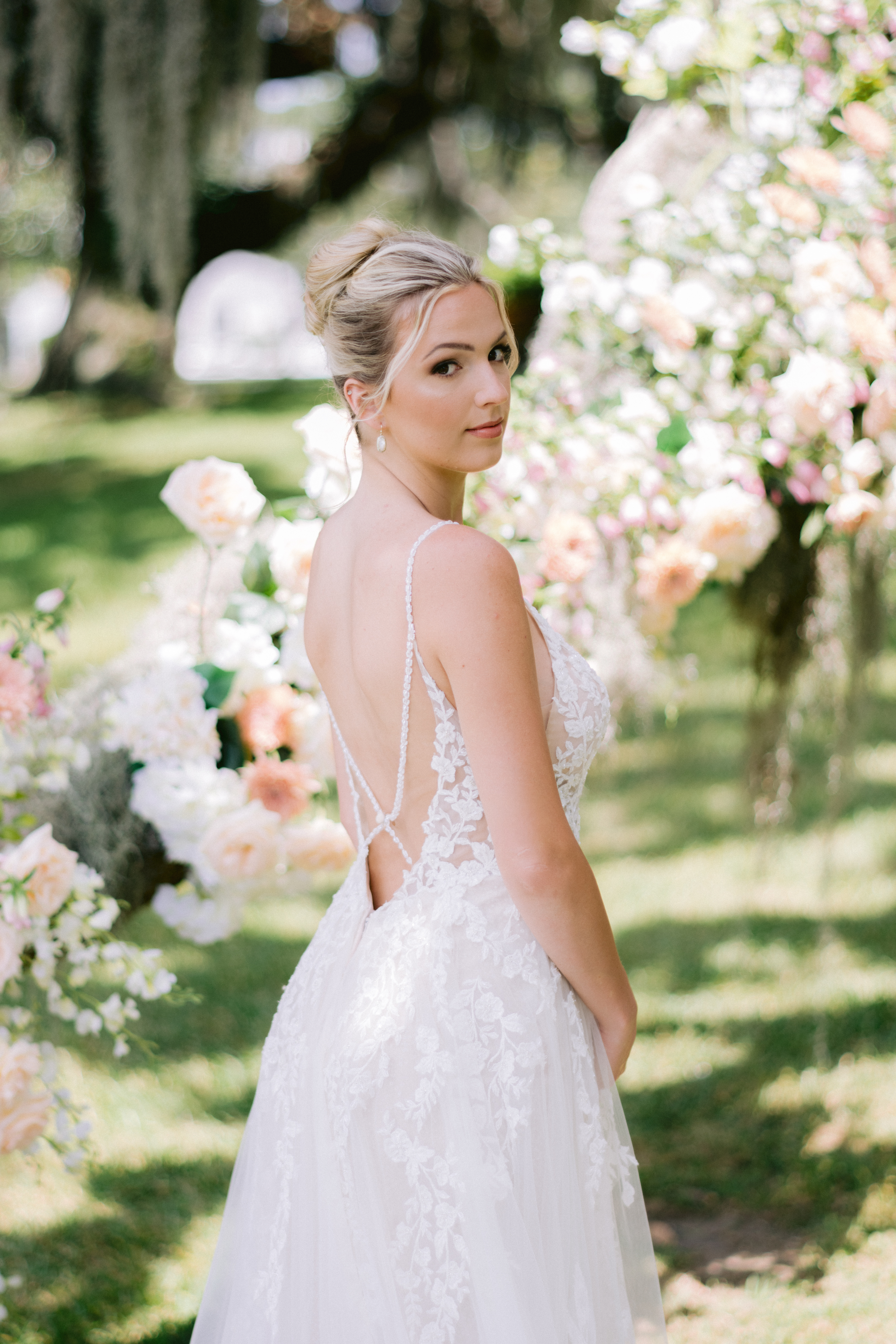 bride looking back at camera in her white lace wedding dress