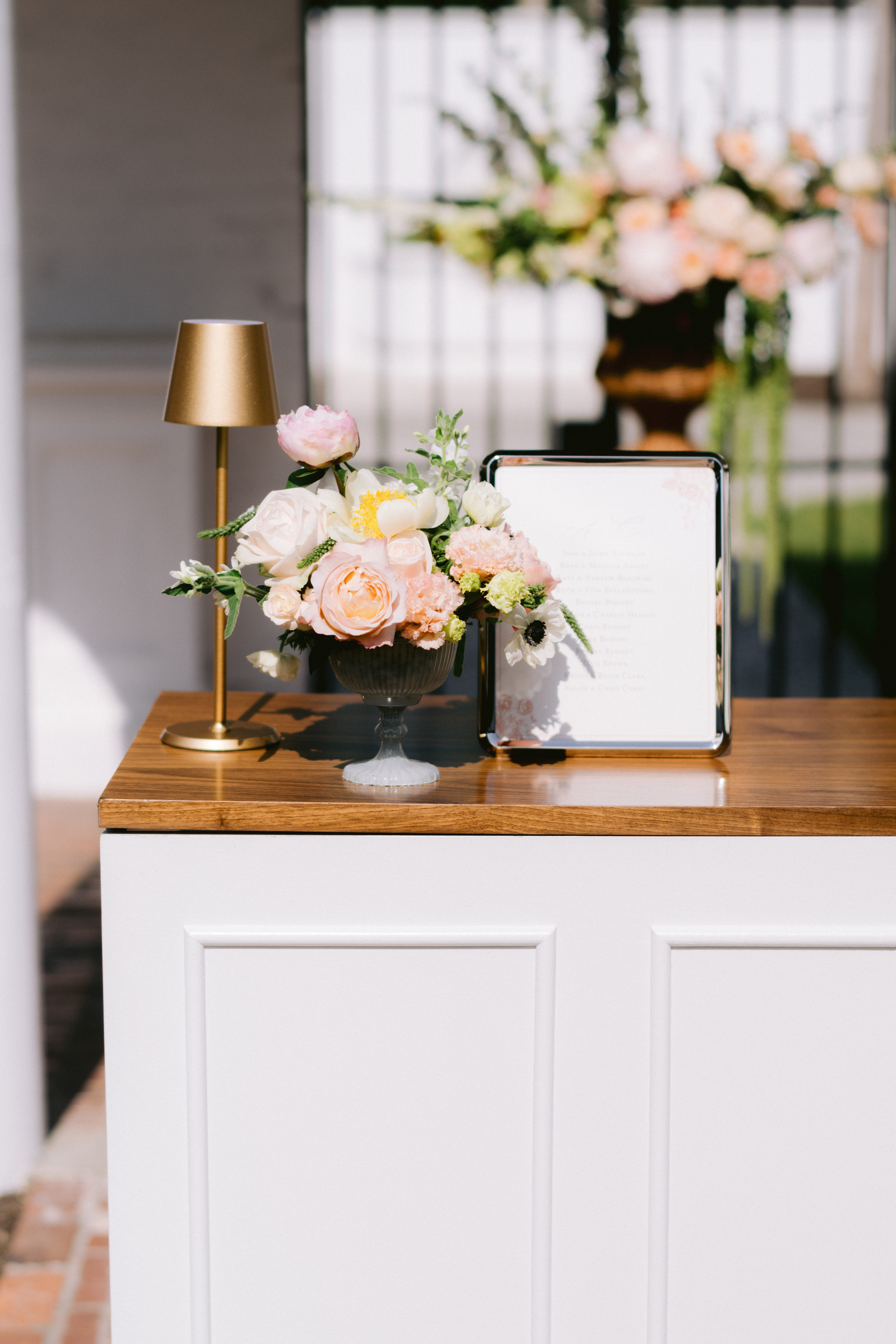 wedding flowers on desk with bar sign