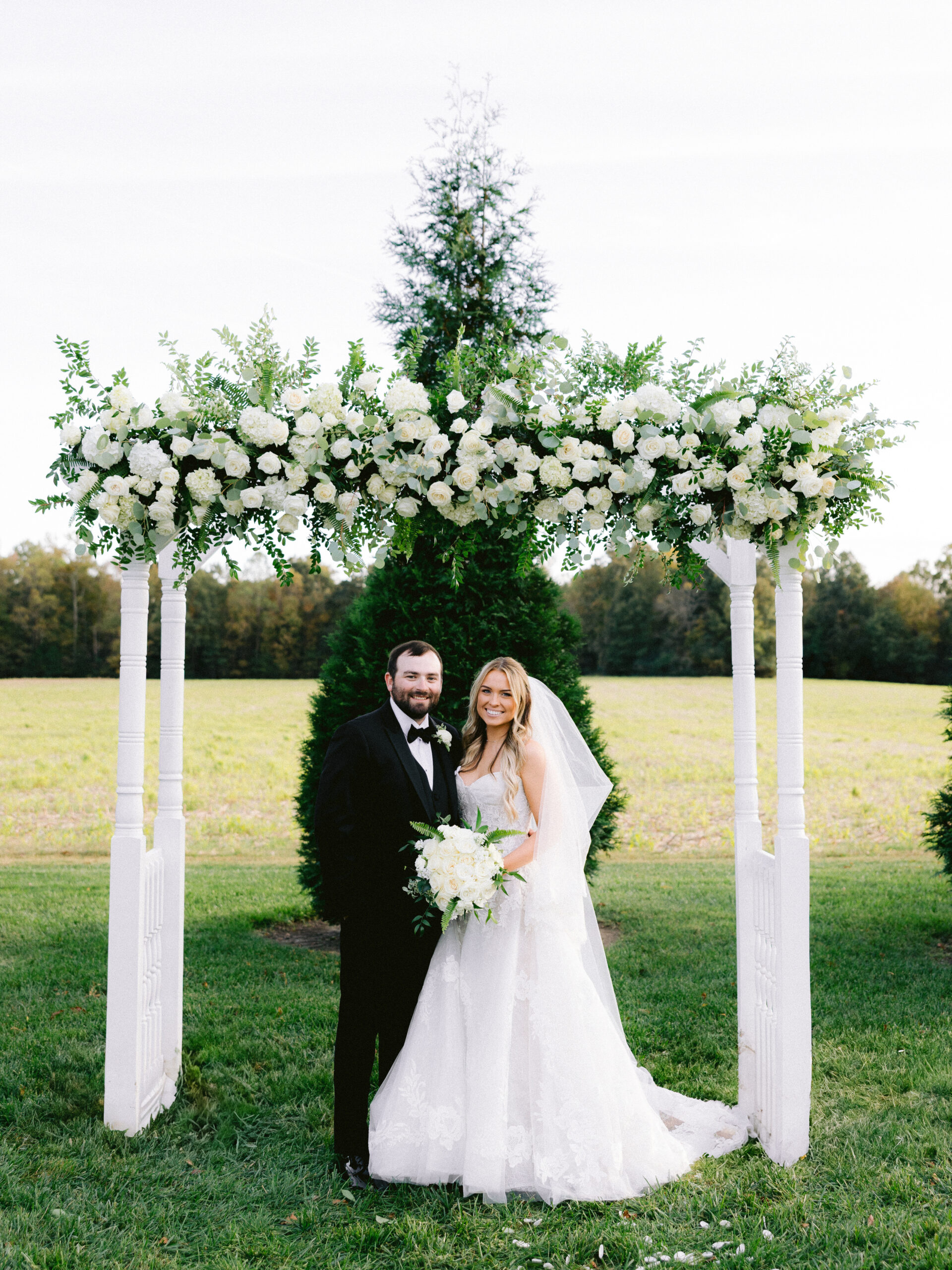 bride and groom under the altar looking at the camera
